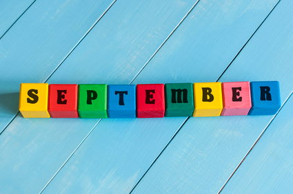 September sign on color wooden cubes with light blue wood background