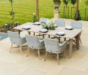 An outdoor table and chairs replete with crockery and cutlery.