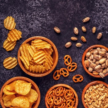 An array of party snacks, including crisps, nuts and pretzels.