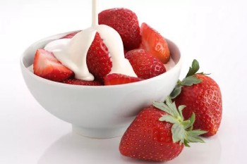 An inviting bowl of strawberries & cream.