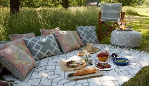 Rugs and comfy cushions laid-out for a garden picnic.